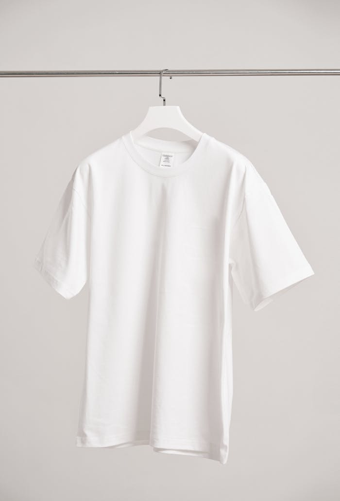 Mastering the First Impression: Your intriguing post title goes here Simple white t-shirt hanging in a modern Shanghai boutique, emphasizing fashion minimalism.